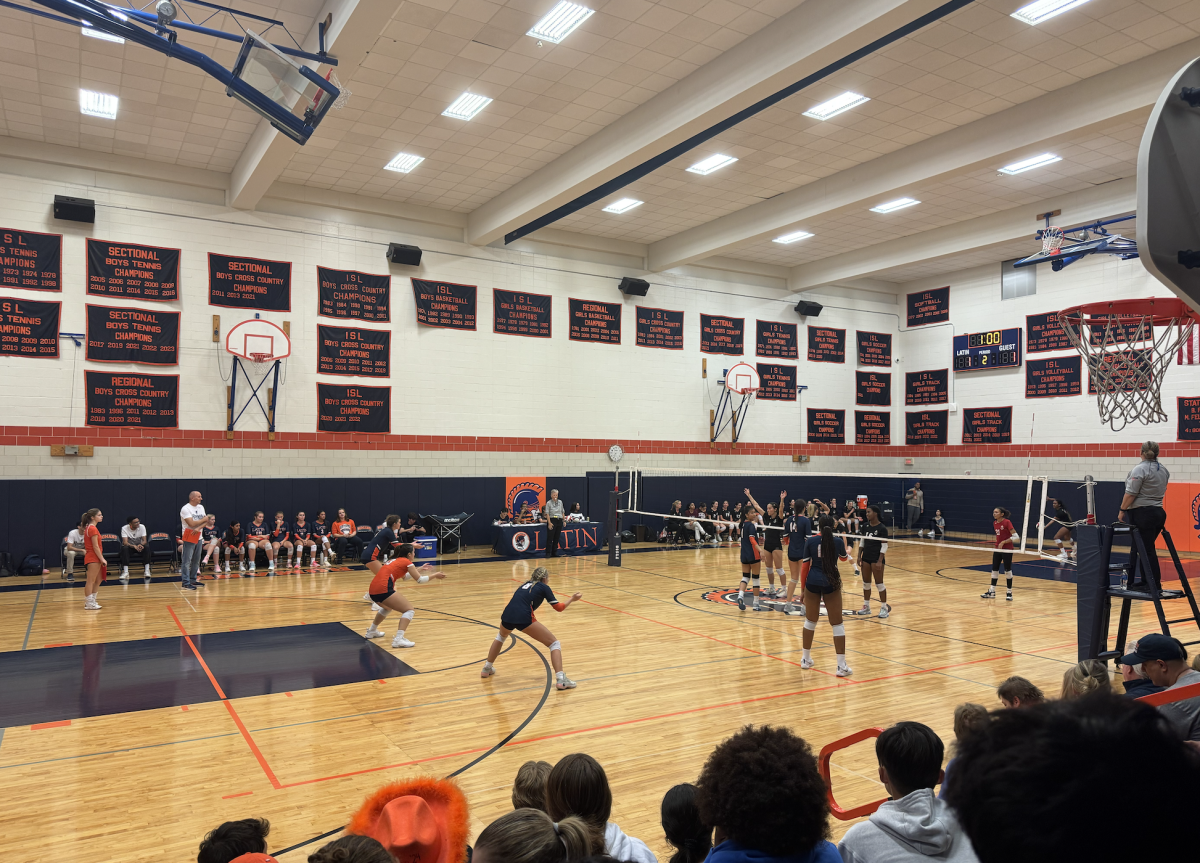 The varsity girls' volleyball team gets ready to receive the ball.